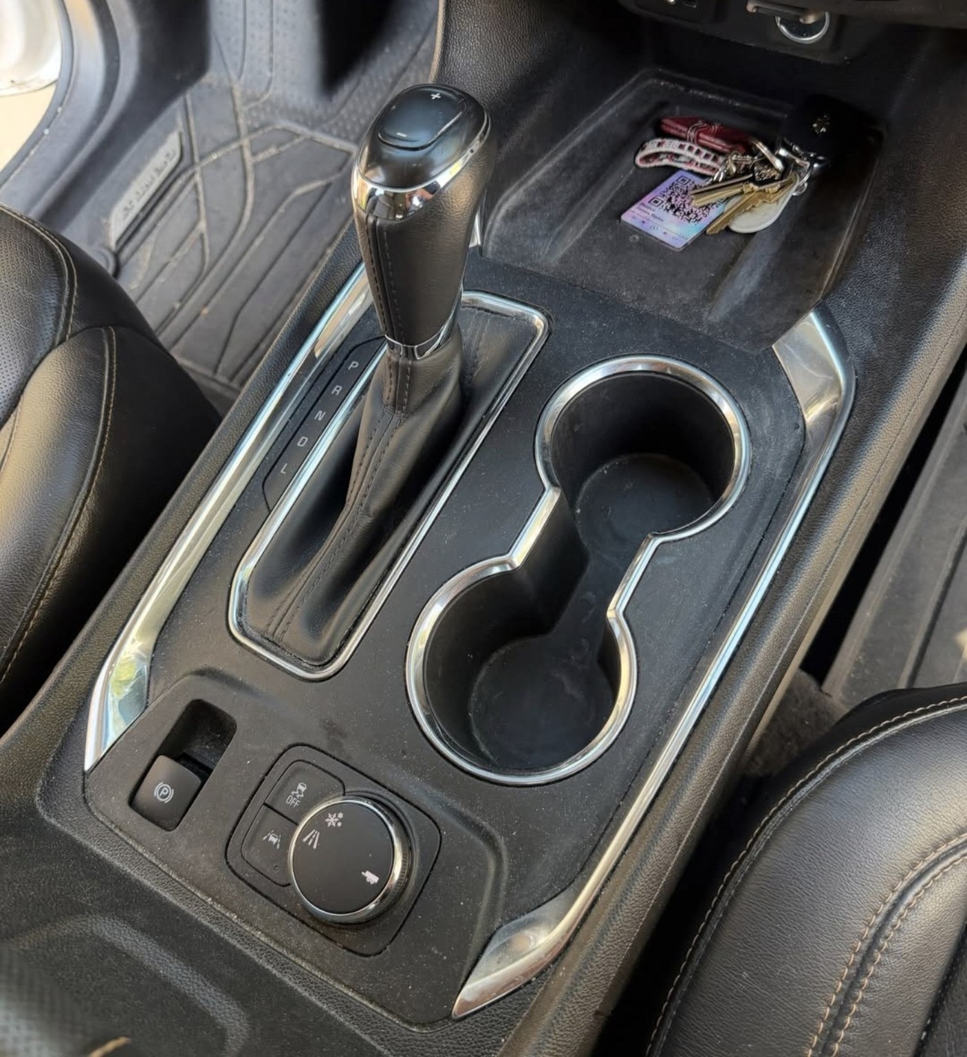 Chevrolet center console before detailing, showing dust around the cup holders and shifter