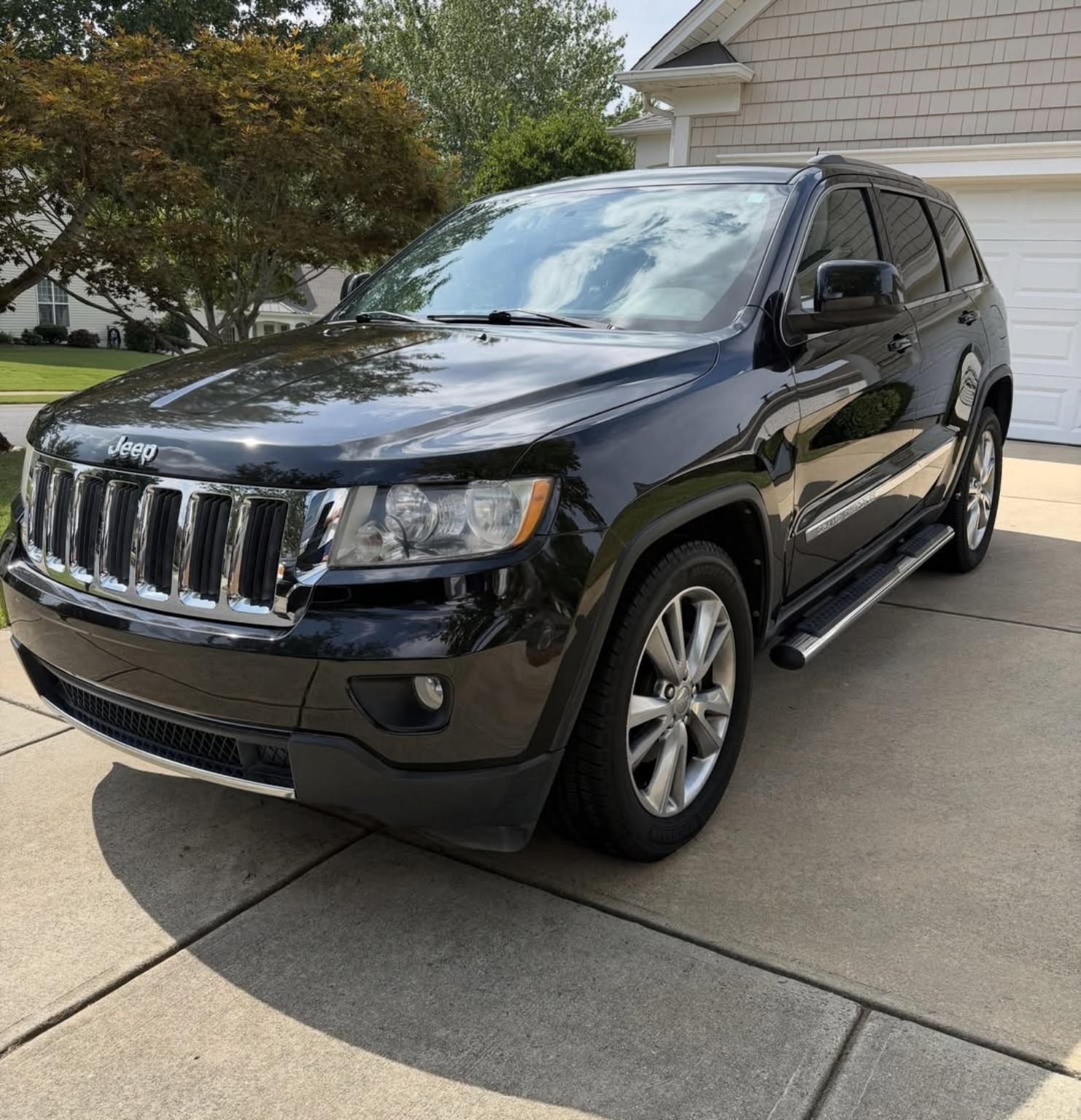 Black Jeep Grand Cherokee after detailing, with a clean glossy finish