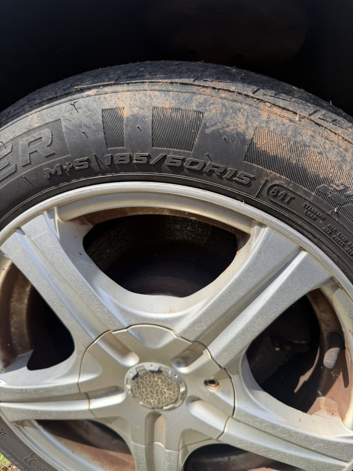 Toyota Avalon wheel and tire before cleaning, showing dirt and brake dust